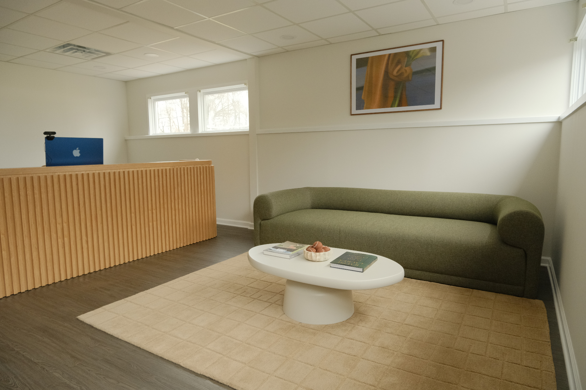 Reception lounge with green couch and oval coffee table
